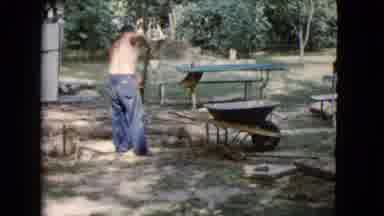 Wauconda Illinois USA (1960): Shirtless Man Shovels Dirt From Wheelbarrow Into