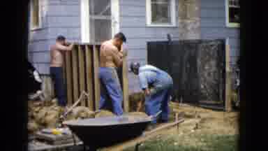 Wauconda Illinois USA (1960): Men Build Wall Behind The House Together And One Is