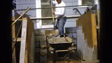 Wauconda Illinois USA (1960): Man Unsteadily Shoveling Building Material Behind