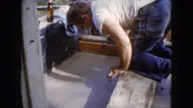 Wauconda Illinois USA (1960): Man Diligently Smooths The Wet Pavement Making Sure