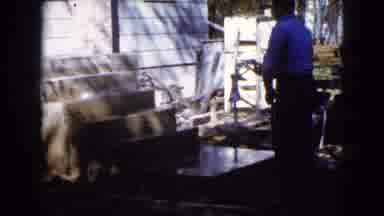 Wauconda Illinois USA (1960): Man Uses Hose To Spray Down Concrete Of New Porch