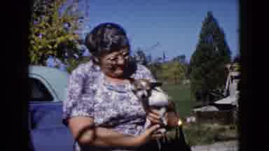 Wauconda Illinois USA (1960): An Elderly Woman Standing Near A Car Coddling A