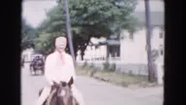Buffalo New York USA (1961): A Woman Horseback Riding Past Some Houses While