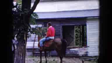 Buffalo New York USA (1961): Man In Red Shirt Rides A Horse
