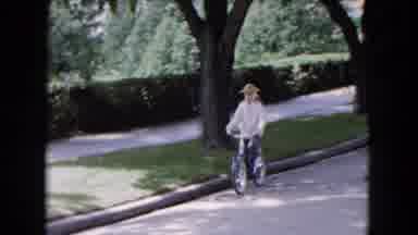 Buffalo New York USA (1961): Child Wearing A Pointed Hat Riding A Bicycle Down The