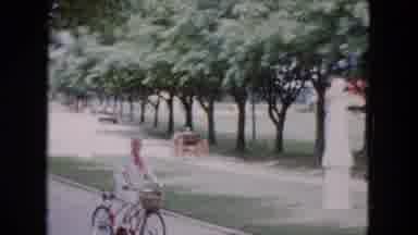 Buffalo New York USA (1961): Smiling Woman With Pink Scarf Riding A Bicycle In A