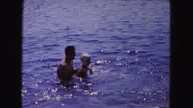 Buffalo New York USA (1961): A Male Helping A Young Child In A Swim Cap Learn To