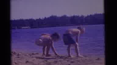 Camden New Jersey USA (1961): Two Children Wearing Shorts Play In The Sand Next To