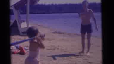 CAMDEN NEW JERSEY USA-1961: Little Girl Swings Plastic Bat And Misses Ball At Beach