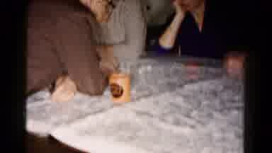 Hagerstown Maryland USA (1961): People Playing A Game On A Table As A Child Crawls