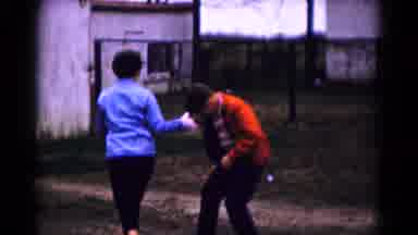Hagerstown Maryland USA (1961): Two People Mischievously Throwing Things Over A