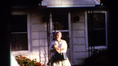 Catskill New York US (1962): Lady Walking From A House Holding A Small Dog