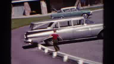 Catskill New York US (1962): Child Walks On Rail In Parking Lot In A Red Shirt As