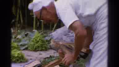 Catskill New York US (1962): Man With Chef Hat Outside Bent Over Grabbing Wood
