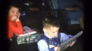 Catskill New York US (1962): Little Children Open Presents While Adults Look On