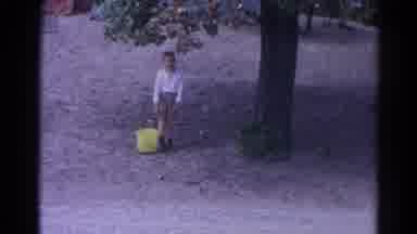 Catskill New York US (1962): Young Boy Struggling To Carry A Large Yellow Bucket