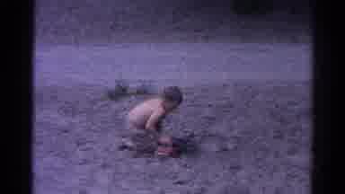 Catskill New York US (1962): Little Boy Plays In Sand On A Cloudy Day With A Red