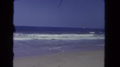 Los Angeles California USA (1962): Person Wading Into The Shore Of A Beach As