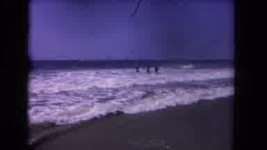 Los Angeles California USA (1962): Four People Stand Facing Waves Of Ocean On