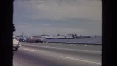 Los Angeles California USA (1962): Driving Along A Two Lane Road Along The Water's