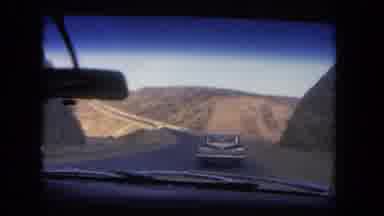 Los Angeles California USA (1962): Vintage Cars Driving Down The Road Going Past