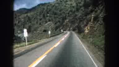 Summit County Colorado USA (1962): Driving Slowly Down The Road Through A Valley