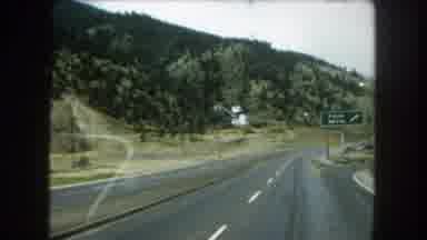 Summit County Colorado USA (1962): Driving Down A Highway With Hills And Trees To