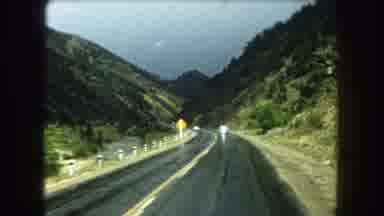 Summit County Colorado USA (1962): A Car Driving Leisurely Down A Mountain Road