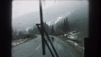 Summit County Colorado USA (1962): A Bus Riding Down The Street While Raining