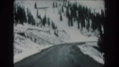 Summit County Colorado USA (1962): Moving Shot Of Wet One Lane Road Through Snow