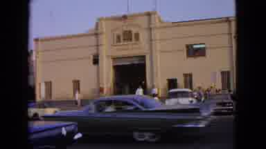 Barrington Illinois USA (1963): Man Crossing Street With Cars Passing By To Enter