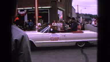 Barrington Illinois USA (1963): Two Convertible Cars Drive By In A Parade With Men
