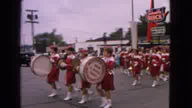 Barrington Illinois USA (1963): Marching Band In Red Uniforms Rounding The Corner