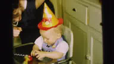 Camden New Jersey (1963): Baby Wearing Yellow Party Hat Sits In White Highchair