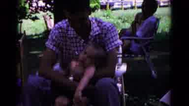 Cold Springs New York USA (1963): Man With Baby Is Sitting Down And Feeding Him