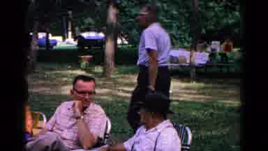Cold Springs New York USA (1963): Man Walking By Groups Of People In A Wooded