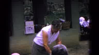 Cold Springs New York USA (1963): Woman Wearing White Shirt Picks Up Blue Baby