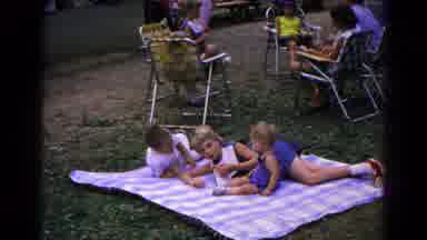 Cold Springs New York USA (1963): Children Playing On Picnic Blanket Blowing Up A