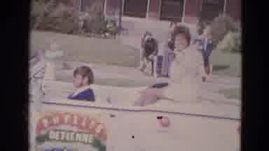 Lincoln Nebraska (1963): Lady Riding On The Back Of A Car Waving As Two Children