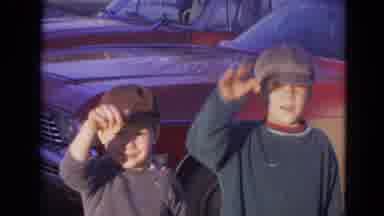 Lincoln Nebraska (1963): Two Boys Stand In Front Of Red Car Waving At Camera On A