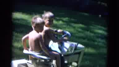 Lincoln Nebraska (1963): Two Children Ride On Small Motorized Lawn Mower Outside