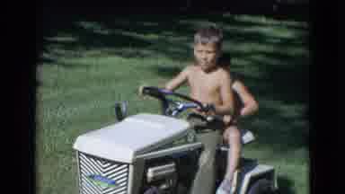 Lincoln Nebraska (1963): Two Young Shirtless Boys Enjoy Piloting A Riding Lawn