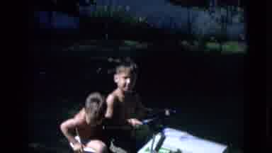Lincoln Nebraska (1963): Two Little Boys Riding On A Toy Tractor In The Grass