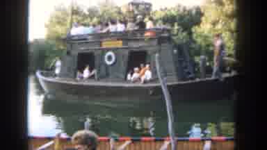 Disneyland California (1962): A Wooden Boat Sails Down River Past A Burning