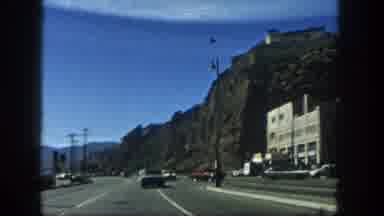 San Diego California (1962): Cars Drive Down A Highway In A Mountainous Area With