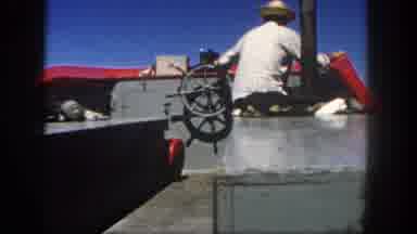 San Diego California (1962): Man With Straw Hat Steering A Boat Then Shot Of Coast