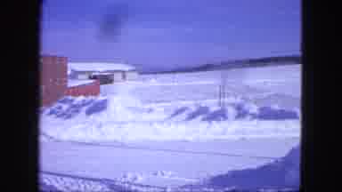 Proctor Minnesota (1963): Panning Shot Of Snowy Field Beside Brick Building