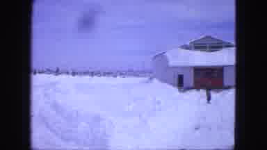 Proctor Minnesota (1963): Person Walks Alone In Snow Outside Building On Cold