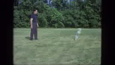 Saint Paul Minnesota (1963): A Man Playing Fetch With A Small White Dog Outdoors