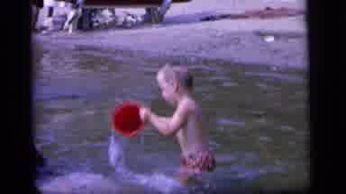 Camden New Jersey (1964): Child Playing With Bucket On The Lake With His Mother